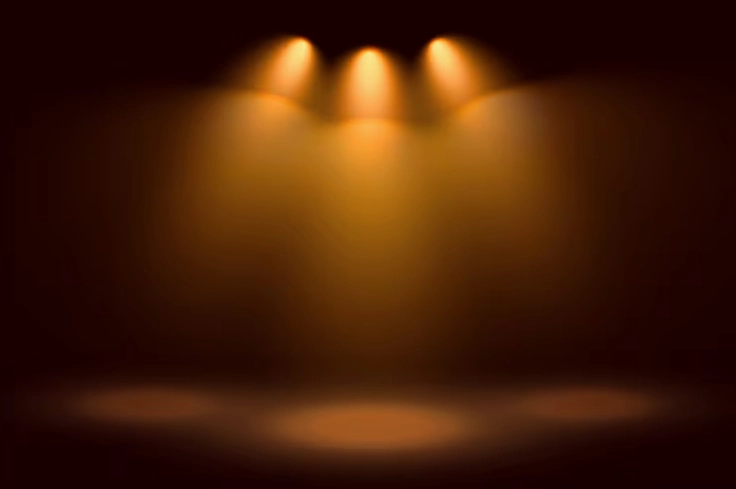 Nền sân khấu với ba đèn rọi ánh sáng vàng