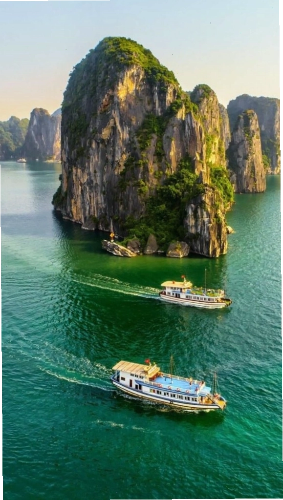 Du thuyền nhỏ giữa vịnh biển xanh biếc và những dãy núi đá bao quanh