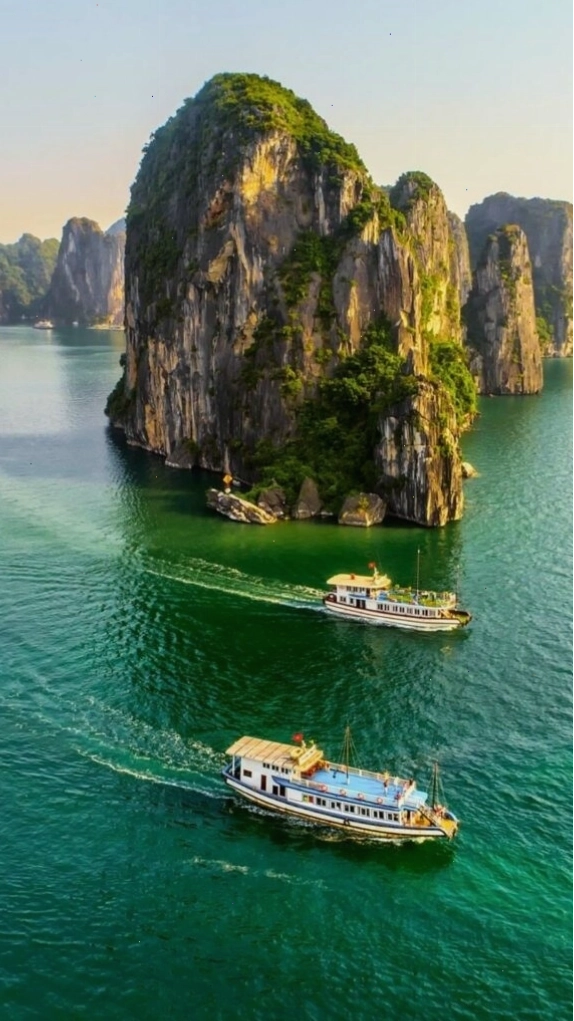 Du thuyền nhỏ giữa vịnh biển xanh và núi đá