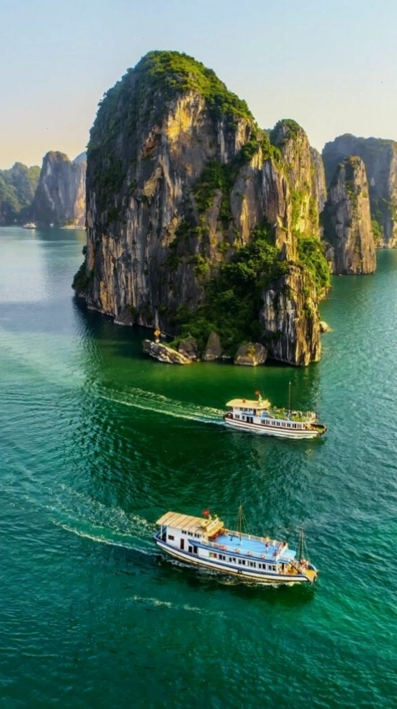 Du thuyền nhỏ giữa vịnh biển xanh với ánh sáng lấp lánh