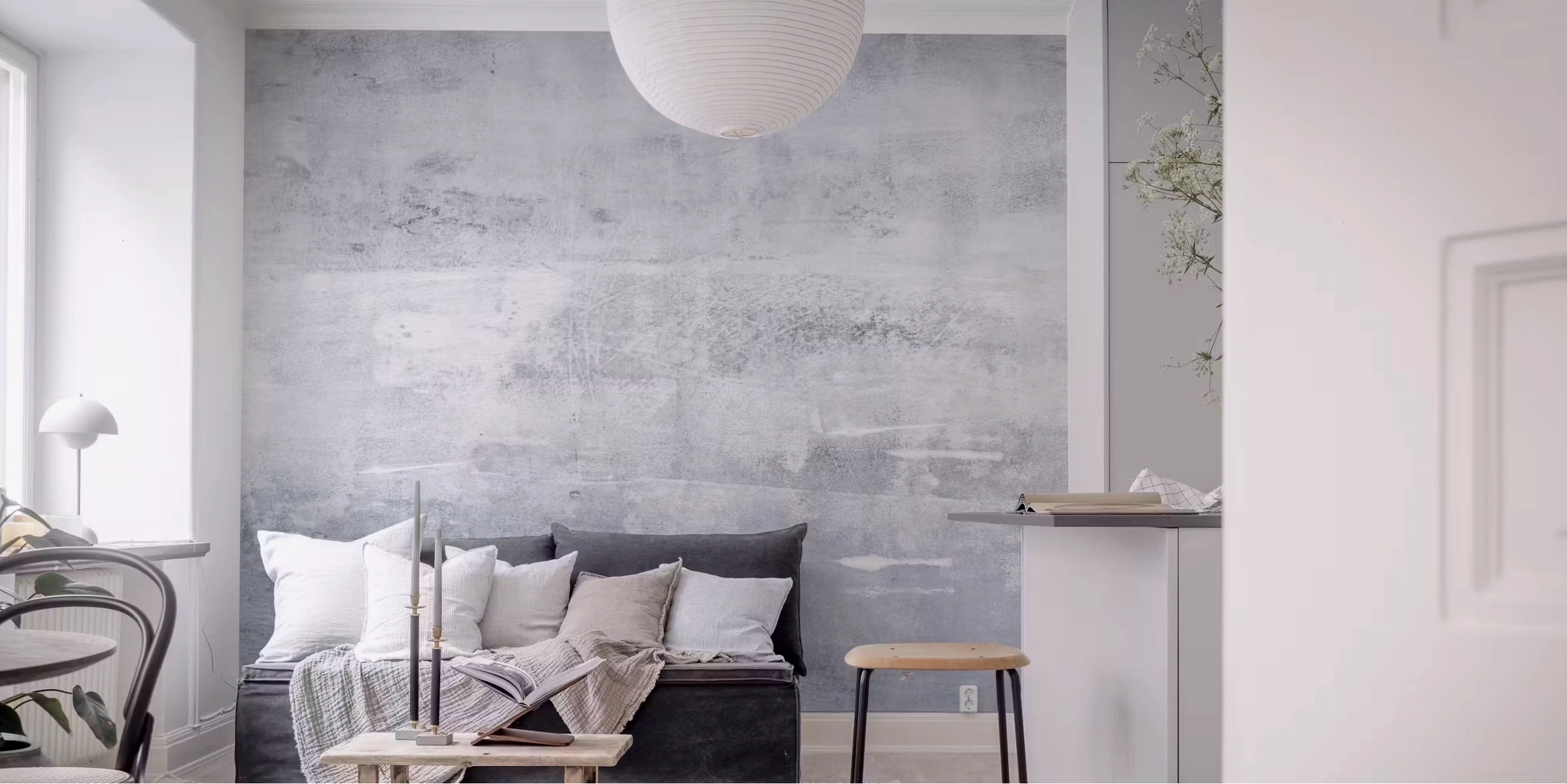 Light grey concrete look wallpaper in a room with large windows